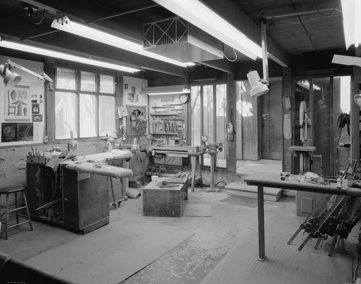 Black and white photo of Sam Maloof's workshop with workbenches and tools