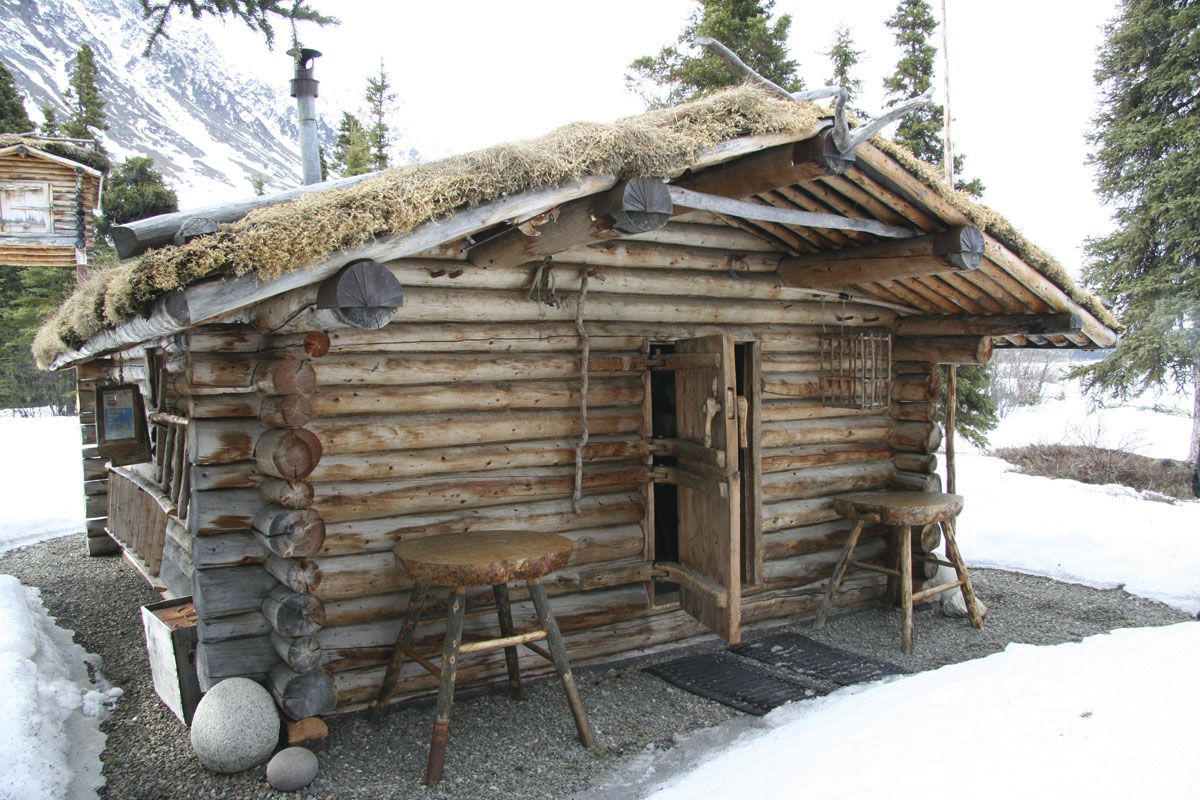 Proenneke's log cabin with a sod roof in winter